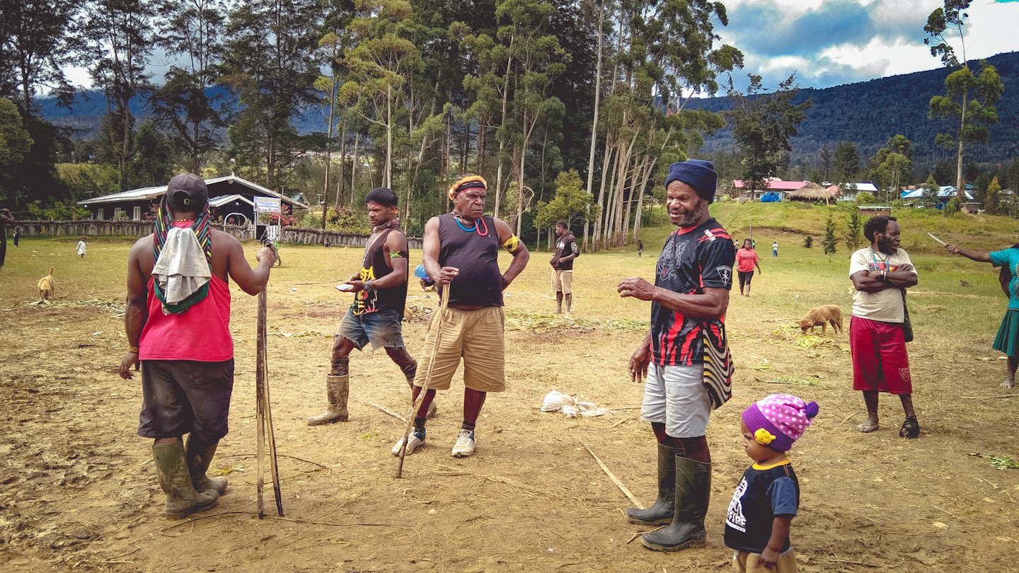 A group of people standing together in a rural field.