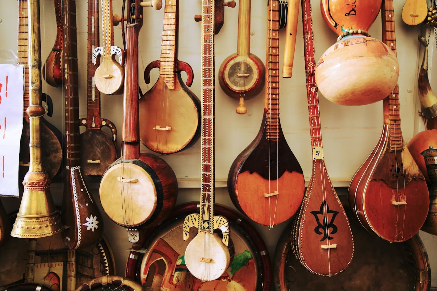 Traditional wooden stringed instruments hang displayed on a wall.